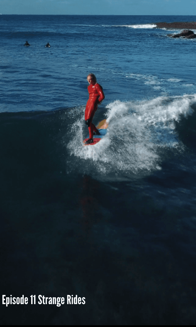 london in red wetsuit doing a hangfive on a bonzer