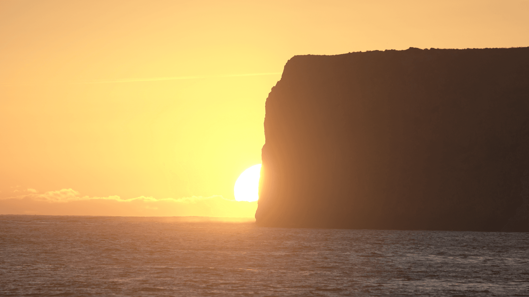 algarve sunset behind cliff